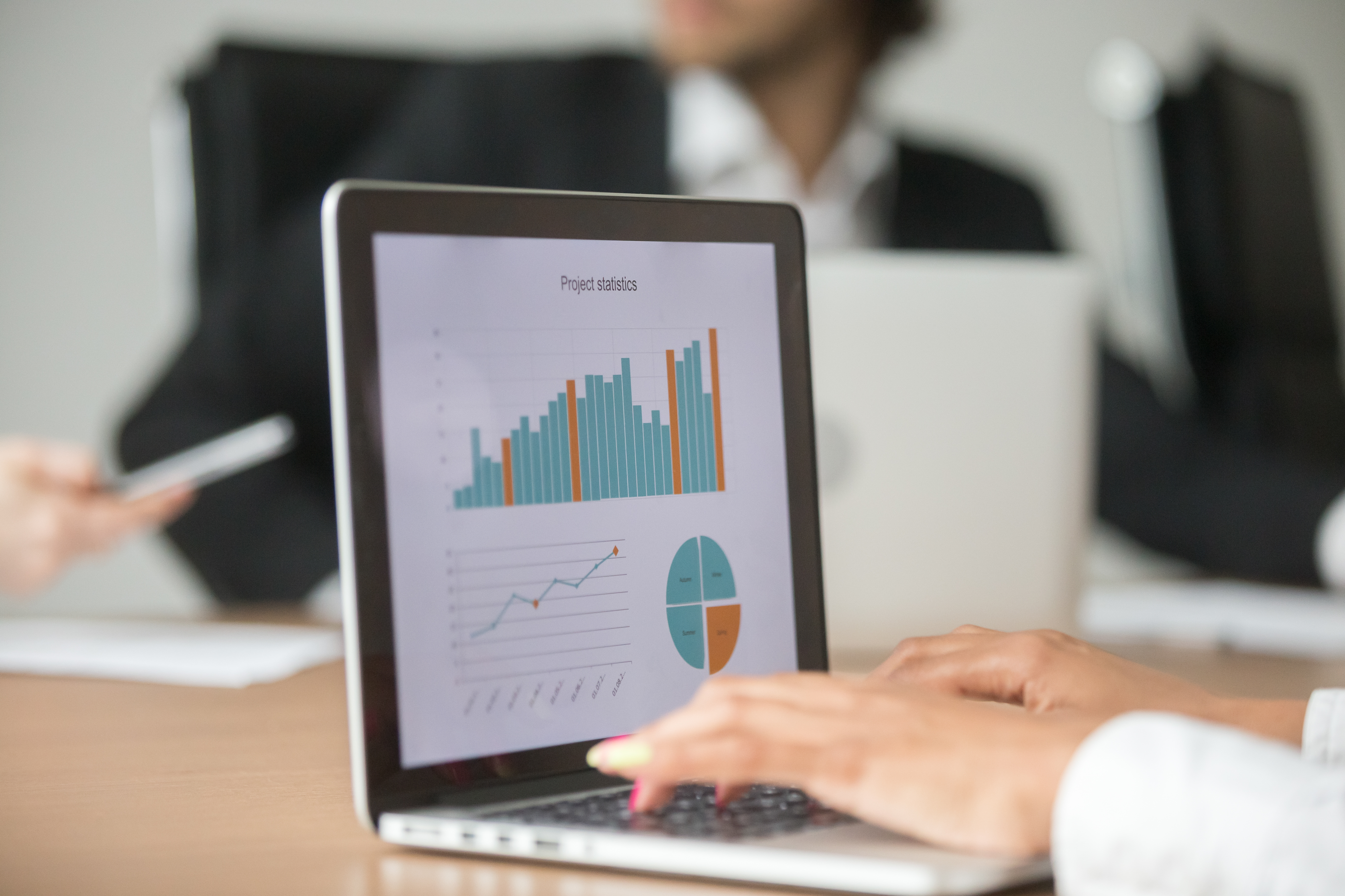 Businesswoman Working With Statistical Report At Team Meeting An